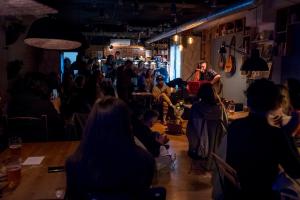 a man standing in a room with a crowd of people at Olé Backpackers Hostel in Alicante