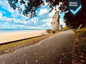 a building on the beach next to the ocean at George Street House in Ryde