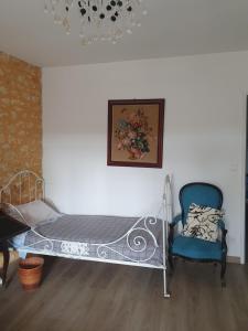 a bed and two chairs in a room at Gîte à la campagne "Le Luquet" in Chazelles +4 photos
