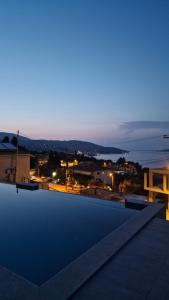 a view of a city at night from a roof at 3 Keys Luxury Apartment in Nikiana