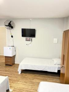 a room with two beds and a fan and a tv at Hotel Econômico in Volta Redonda +12 photos