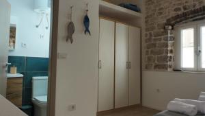 a bathroom with white cabinets and a brick wall at Casa Blu in Šibenik +48 photos