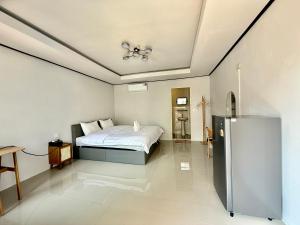 a bedroom with a bed and a refrigerator in it at Tawee Green Boutique hotel in Phra Nakhon Si Ayutthaya