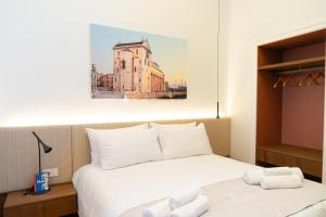 a hotel room with a bed and a picture of a building at Cala Bianca in Trani
