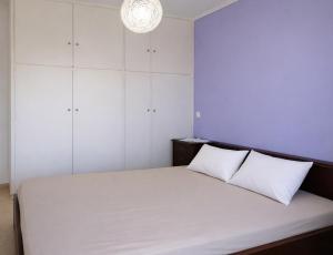 a bedroom with a large white bed with two pillows at Beachfront Absolute Bliss in Perigiali, Korinthia in Periyiálion