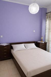 a bedroom with a large bed with a purple wall at Beachfront Absolute Bliss in Perigiali, Korinthia in Periyiálion