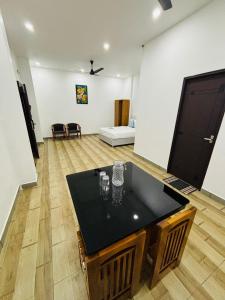 a living room with a table and a flat screen tv at MIRACLE Inn in Alwaye