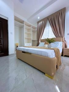 a bedroom with a large bed with a large window at Chevy Chase Gardens, 9 in East Legon