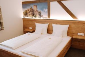 a bed in a room with a picture on the wall at Hotel zur Post e.K. in Waischenfeld