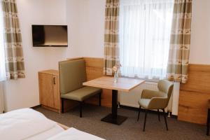 a room with a table and two chairs and a bed at Hotel zur Post e.K. in Waischenfeld