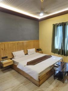 a bedroom with a large bed and a table at Hotel Unique Villa in Mount Ābu