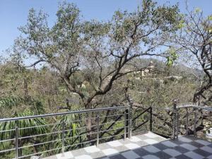 a walkway with a fence and trees in the background at Hotel Unique Villa in Mount Ābu +45 photos