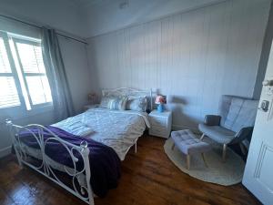 a bedroom with a bed and a chair at Seaside Sanctuary in Aspendale