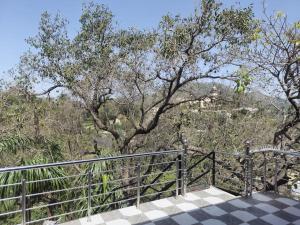 a walkway with a fence and trees in the background at Hotel Unique Villa in Mount Ābu