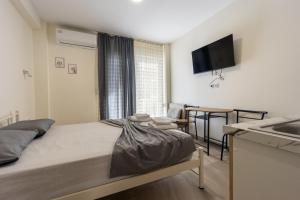 a bedroom with a bed and a kitchen with a sink at Dimitra Beach Apartments 2 in Nea Karvali
