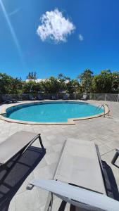 a swimming pool with a chair and a table at Studio LY'S in Saint-François