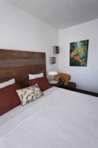 a bedroom with a large white bed with a wooden headboard at Studio LY'S in Saint-François +8 photos
