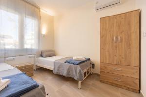 a small bedroom with two beds and a cabinet at Dimitra Beach Apartments 2 in Nea Karvali