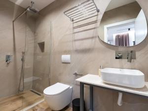 a bathroom with a toilet and a sink and a mirror at Enigma Rooms in Lezhë