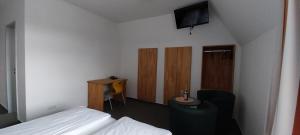 a hotel room with a bed and a television at BBZ Burg Weißensee in Weißensee +4 photos