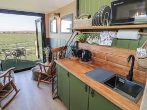 a kitchen with a counter with a sink and a table at GiGi's Horsebox in Evesham