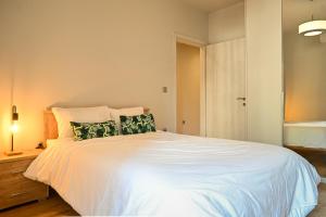 a bedroom with a large white bed with green pillows at Thessaloniki Central Luxe in Thessaloniki