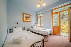 a bedroom with two beds and two windows at Magnolia Tbilisi in Tbilisi City +83 photos