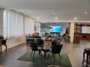 a lobby with chairs and tables and a living room at Hotel Mio City in Kula
