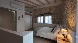 a bedroom with a bed and a brick wall at Casa Blu in Šibenik