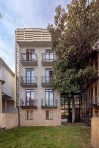 an apartment building with balconies and a tree at Magnolia Tbilisi in Tbilisi City