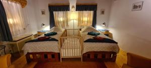 a bedroom with two beds and a window at Napsugár Vendégház Nagylóc in Nagylóc