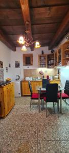 a large kitchen with a table and chairs in it at Napsugár Vendégház Nagylóc in Nagylóc