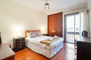 a bedroom with a bed and a large window at GuestReady - Varanda de belas lembranças in Funchal