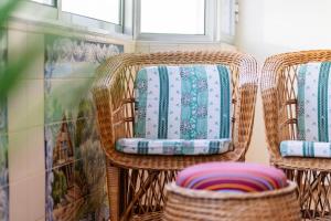 two wicker chairs with colorful cushions in a room at GuestReady - Varanda de belas lembranças in Funchal