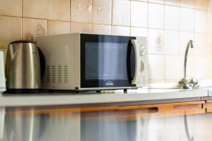 a microwave sitting on top of a kitchen counter at GuestReady - Varanda de belas lembranças in Funchal +27 photos