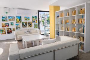 ein Wohnzimmer mit weißen Möbeln und Bücherregalen in der Unterkunft Adia Hotel Cunit Playa in Cunit