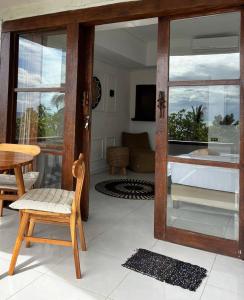 a living room with a sliding glass door and a table and chair at Lombok Coconut Hotel in Mangsit