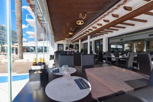 ein Esszimmer mit Tisch und Stühlen und einer Tisch- und Stuhlkonsole in der Unterkunft Adia Hotel Cunit Playa in Cunit