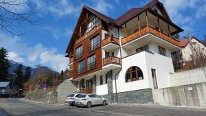 a house with a car parked in front of it at Nobila Sinaia in Sinaia