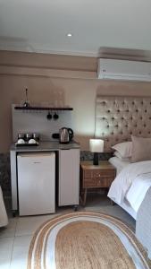 a bedroom with a bed and a kitchen in it at Bohemian Guesthouse - Pretoria in Pretoria +55 photos