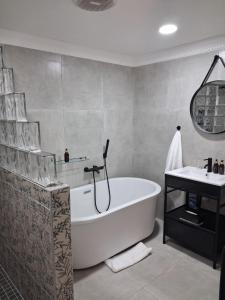 a bathroom with a tub and a sink at Bohemian Guesthouse - Pretoria in Pretoria