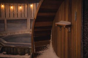 a room with a tub and a staircase with snow at Hótel Lækur in Hella