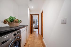 a kitchen with a washer and dryer in a room at Eagle's Nest in Worplesdon
