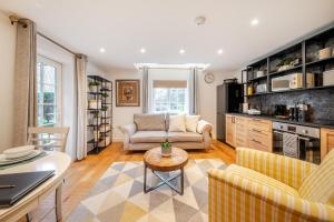 a living room with a couch and a table at Eagle's Nest in Worplesdon