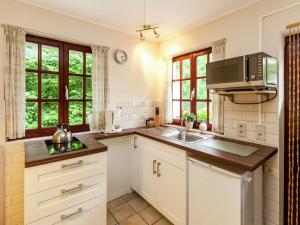 a kitchen with a sink and a microwave at Apartment situated on a magnificent estate in Barvaux
