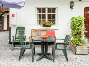 バルヴォーにあるApartment situated on a magnificent estateの白い家の前のパティオテーブルと椅子