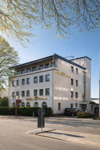 a white building with a sign on the front of it at Hotel Wania in Hamburg