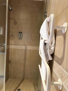 a bathroom with a shower with towels hanging on the wall at Bohemian Guesthouse - Pretoria in Pretoria
