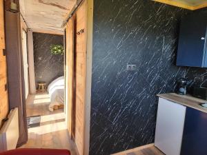 a room with a black wall with a room with a bed at Le Nid Douillet du Tacot in Le Thillot