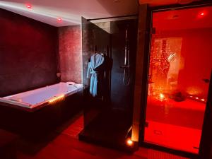 a bathroom with a tub and a shower with red lights at Cocon détente pour 2 avec hammam et jacuzzi privé Mer Lac in Le Barcarès +26 photos